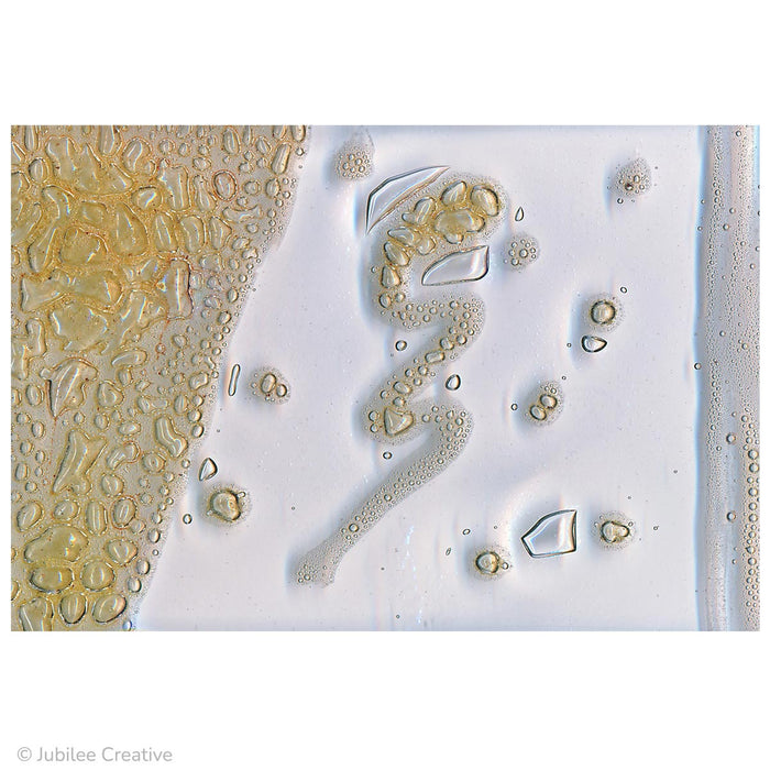 image of butterscotch yellow bubble art paint fused between two pieces of glass. After fusing yellow-colored bubbles of all sizes are shown.