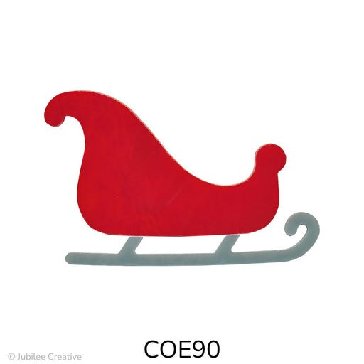 Image shows a red glass sleigh with a high curved front and rounded back, sitting on gray runners. The sleigh has a smooth, festive shape and is cut from two pieces of opaque fusible glass.