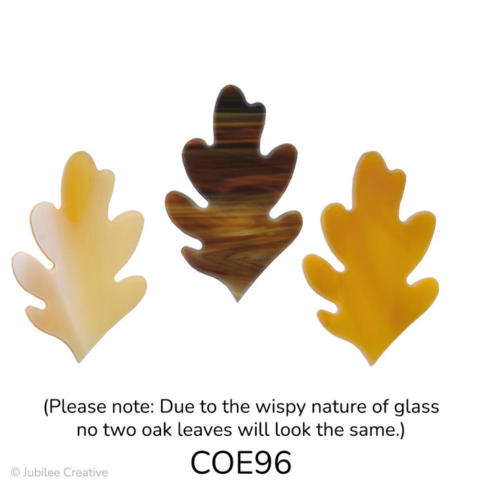 Image shows three glass oak leaves in autumn shades. Each leaf has a classic lobed shape and varies in color, including creamy beige, golden amber, and rich brown swirls.