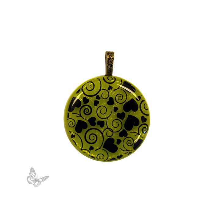 Glass Project: Round pendant with black heart and swirl pattern on a iridized green background.