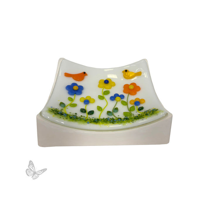 Finished fused glass floral artwork displayed on the Square Slumper B mold, illustrating the gentle curved shape created after slumping.