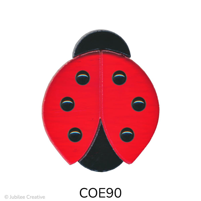 image of a precut fusible glass ladybug with a black head, tail, and dots on a translucent red body - COE90