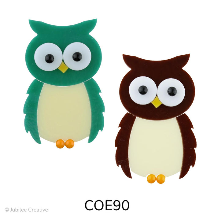 image of a brown and a teal green fusible precut glass owl.  They have white eyes with black pupil, orange beak and feet - COE90