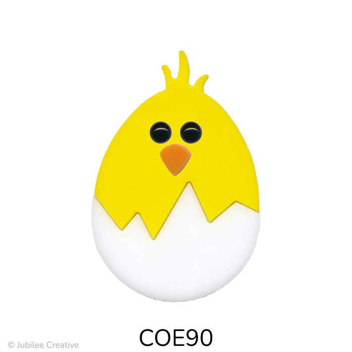 image of a fusible precut white glass egg with a yellow chick with black eyes and an orange beak hatching out of the egg - COE90