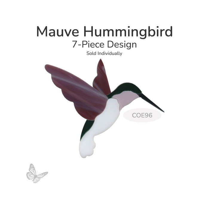 A fusible precut glass hummingbird shown on a white background with text reading 'Mauve Hummingbird', '7-Piece Design', and 'Sold Individually'. The bird has mauve wings, a dark green head and back, a white belly, and a pale pink neck. COE96