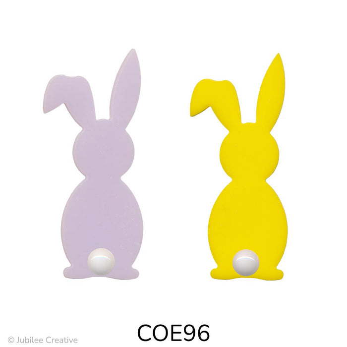 image of two fusible precut glass bunnies with a cotton ball for a tail. One bunny is opaque pink and the other is opaque yellow - COE96