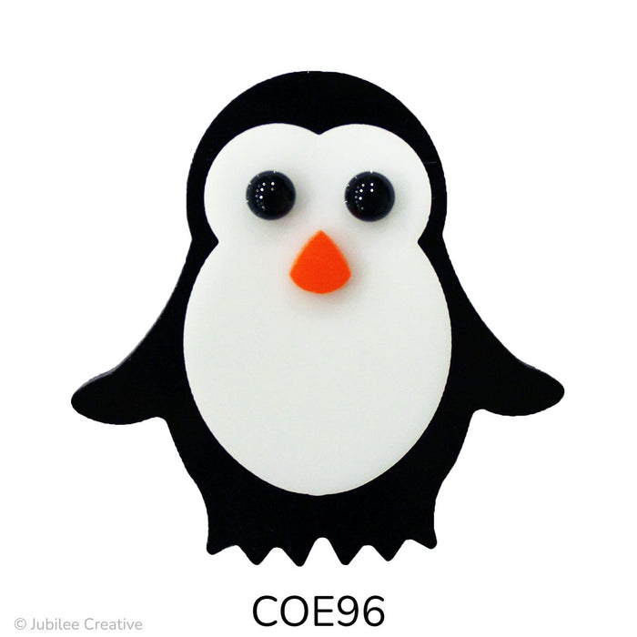 image of a fusible precut glass penguin. He is black with a white belly, black eyes, and an orange nose COE96