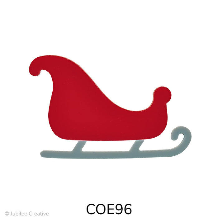 Image shows a red glass sleigh with a high curved front and rounded back, sitting on gray runners. The sleigh has a smooth, festive shape and is cut from two pieces of opaque fusible glass.