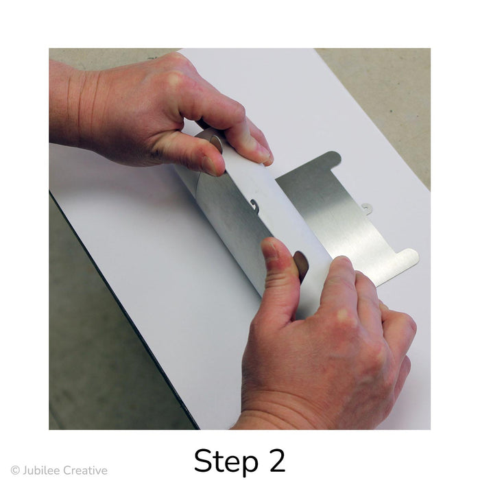 image of Step 2. Holding the pipe down firmly with both hands, grasp the tabs with your thumbs and pull them up and over to create your initial curve