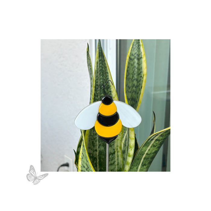 Finished fused bee glass artwork mounted on a garden stake and displayed in a potted plant